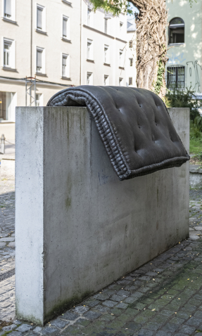 Image of a fountain sculpture by Tatiana Trouvé on Stephansplatz. The sculpture consists of a cast of a mattress placed over a concrete base.