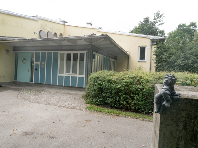 Pumuckl sits on a concrete plinth in front of a shelter in Freiham