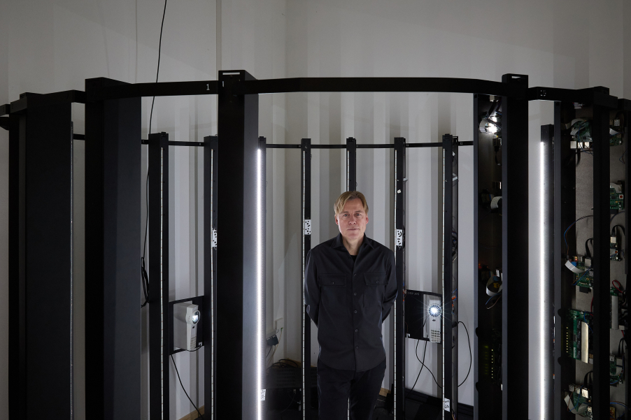 The artist Gregor Schneider looks head-on into the camera from a 3D scanner.